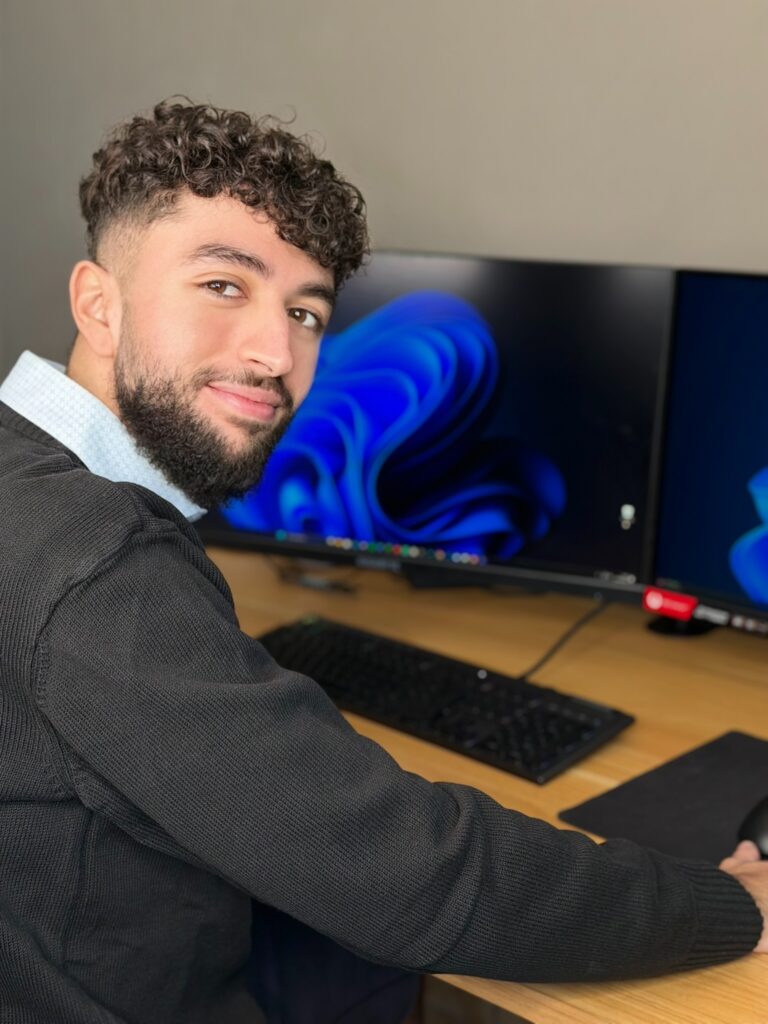 En train de coder sur mon ordinateur regardant le photographe et souriant